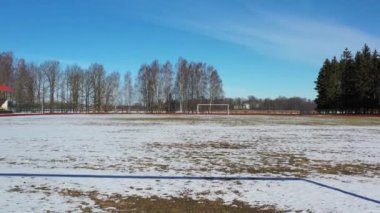 Empty football field covered snow  in winter time, aerial view