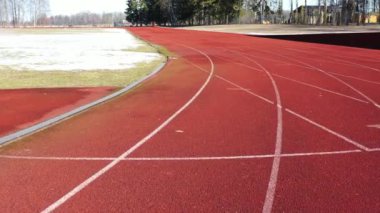 Athletic Running track in old stadium with snow in early spring, aerial view