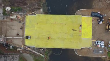 Drone fly up above bridge construction works, aerial view