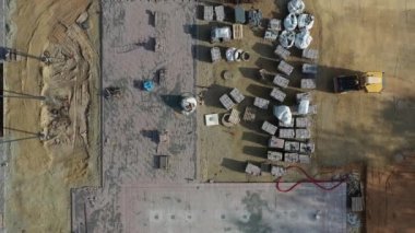Drone flying up above new city square construction site, aerial view