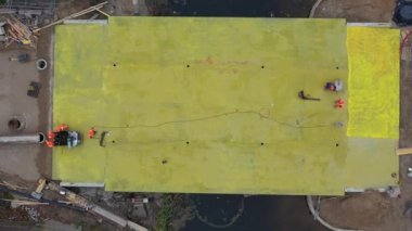 Drone flyig up above bridge construction works, aerial view