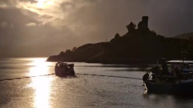 Bir balıkçı teknesi Kyleakin Limanı 'ndan sabah İskoçya, Skye' da ayrılıyor.