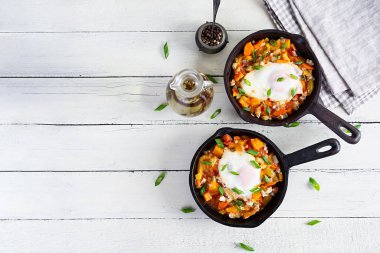 Kızartma tavasında Shakshouka. Sebzeli yumurta, domates, biber, balkabağı ve soğan. Üst görünüm