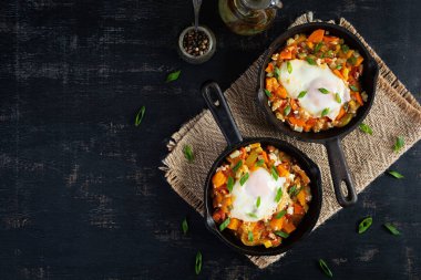 Kızartma tavasında Shakshouka. Sebzeli yumurta, domates, biber, balkabağı ve soğan. Üst görünüm