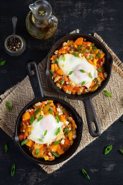 Kızartma tavasında Shakshouka. Sebzeli yumurta, domates, biber, balkabağı ve soğan. Üst görünüm