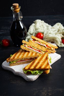 Club sandwich with ham, tomato, green and cheese. Grilled panini