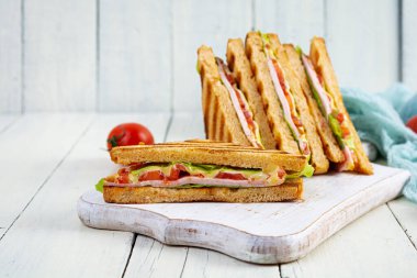 Club sandwich with ham, tomato, green and cheese. Grilled panini