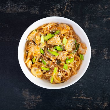 Noodles with vegetables, chicken and mushrooms in bowl. Stir fry pasta. Top view