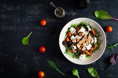 Tavuklu, domatesli, otlu ve peynirli taze salata. Sağlıklı yiyecekler. Üst görünüm