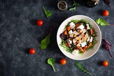 Tavuklu, domatesli, otlu ve peynirli taze salata. Sağlıklı yiyecekler. Üst görünüm