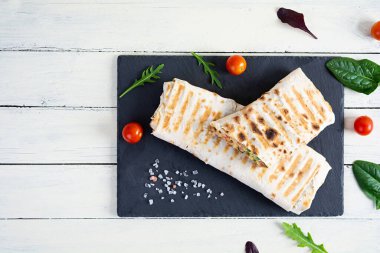 Tahta arka planda salata ve peynirli lezzetli tavuklu shawarma sandviçi