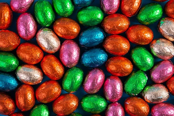 Colorful background of Easter chocolate eggs. Delicious chocolate eggs. Top view