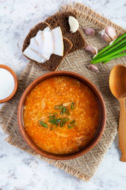 Yeşil soğanlı lahana çorbası, beyaz arka planda ekmek ve salo. Üst görünüm