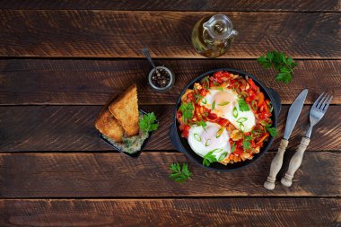 Izgara ekmekli Shakshuka. Domates, biber, sarımsak ve bitkilerle kızarmış yumurta.