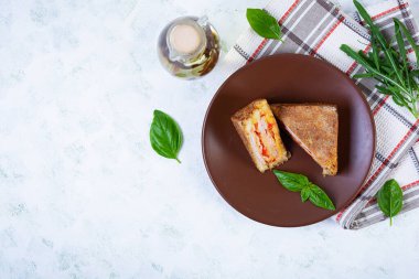 Jambon, peynir ve domatesli ekmek kırıntılarında kızartılmış sandviçler.