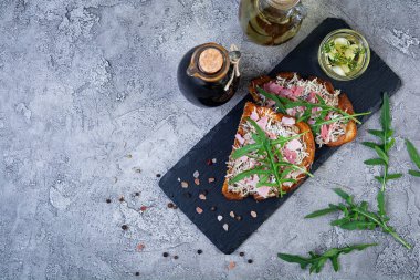 Krem peynir ve otlarla karıştırılmış karamelli soğanlı kızarmış sandviç. Izgara sandviç.