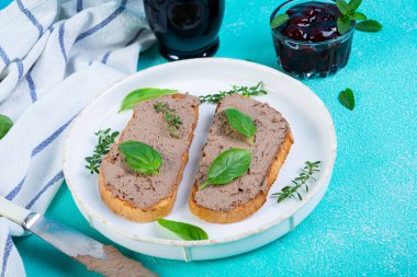 Tavuk ciğeri ve mavi arka planda zeytinli ızgara sandviç.