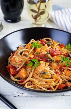 İstiridye, somon ve domatesli deniz ürünleri makarnası. Deniz ürünleri kokteyli ile spagetti.