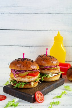 Tavuk pirzolası, domates, turşu ve marullu hamburger. Lezzetli ev yapımı hamburger.