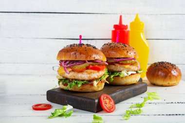 Tavuk pirzolası, domates, turşu ve marullu hamburger. Lezzetli ev yapımı hamburger.