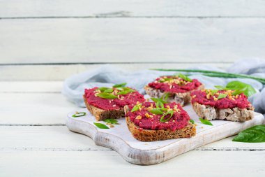 Pancar köklü tostlar, doğranmış fındık ve otlar. Pancarlı vegan bruschetta.