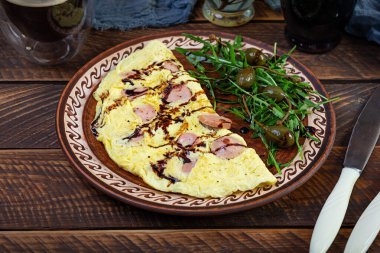 Sosisle doldurulmuş omlet. Roka ve kaparili omlet.