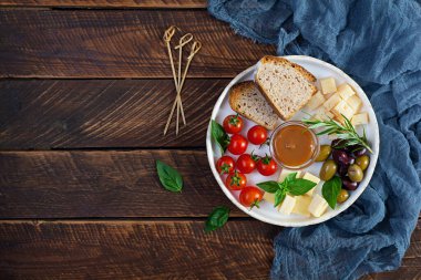 Peynir, zeytin, domates ve tuzlu karamelden yapılmış atıştırmalıklar. Aperatif ya da antipasto tabağı.