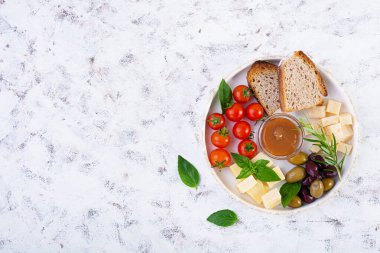 Peynir, zeytin, domates ve tuzlu karamelden yapılmış atıştırmalıklar. Aperatif ya da antipasto tabağı.