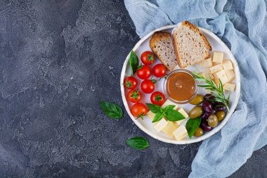 Peynir, zeytin, domates ve tuzlu karamelden yapılmış atıştırmalıklar. Aperatif ya da antipasto tabağı.