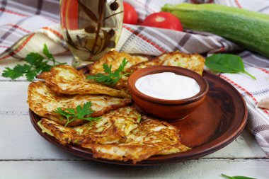 Ekşi kremalı bir tabakta kabaklı börek. Lezzetli kabak köfteleri.