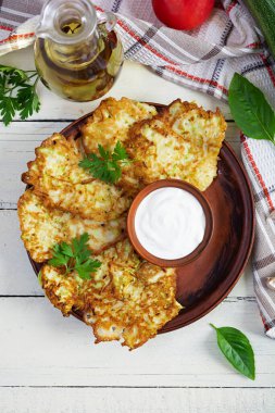 Ekşi kremalı bir tabakta kabaklı börek. Lezzetli kabak köfteleri.