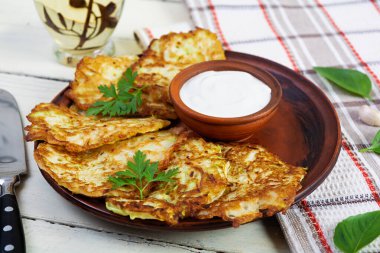 Ekşi kremalı bir tabakta kabaklı börek. Lezzetli kabak köfteleri.