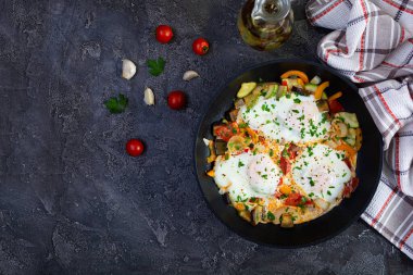 Shakshuka kızartma tavasında. Domates, biber, kabak ve otlu sahanda yumurta.