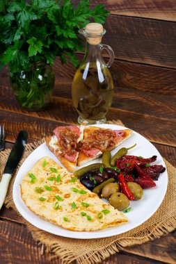 Omelette with toast, olives and sun-dried tomatoes. Tasty omelet breakfast