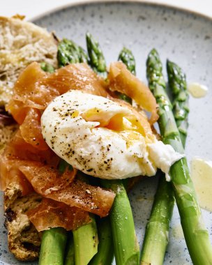 Tütsülenmiş somon, haşlanmış yumurta, haşlanmış kuşkonmaz ve ekşi ekmek.