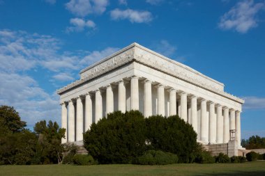Washington DC, ABD - 3 Ekim 2016: Lincoln Anıtı 'nın görkemli ve klasik mimarisini verimli yeşilliklerle çevrili canlı mavi gökyüzüne karşı gösteren çarpıcı bir görüntüsü. Tarih, anıt ve seyahat temaları için mükemmel..