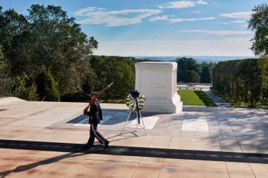 Arlington, Virginia, ABD - 3 Ekim 2016: Meçhul Asker 'in Mezarı' nda devriye gezen bir onur kıtası şehit askerlere saygıyı ve anma törenini simgeliyor. Anıt sakin bir manzarayla çevrili..