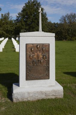 Arlington, Virginia, ABD - 3 Ekim 2016: Arlington Mezarlığı 'ndaki taş bir anıt, Uzay Mekiği Challenger mürettebatını oymalı yüzleri ve isimleriyle onurlandırdı. Durgun, yeşil bir gökyüzünün altında duruyor..