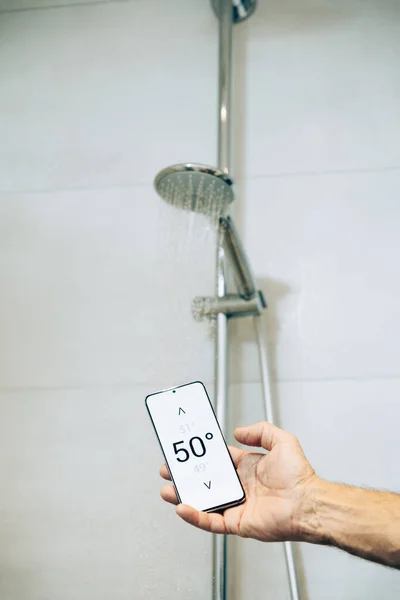 Smart Home Concept Man Controlling Warm Water Temperature Using App Stock Image