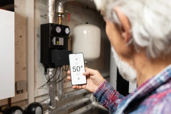 Smart Home Concept Man Controlling His Heating System Using App Stock Photo