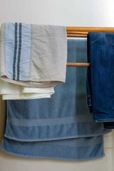 Clothesline Legno Con Asciugamano Jeans Pantaloncini Uomo Vicino Muro Bianco — Foto Stock