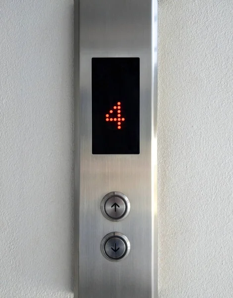 The arrow symbol with the braille on the push button of the metal panel in the passenger elevator, office building in the urban area, front view with the copy space.