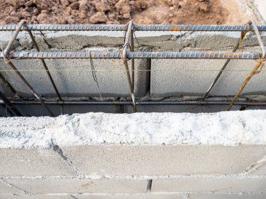 The reinforcement steel bar of the framework on the concrete wall to build the modern house, front view with the copy space.