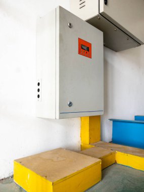 Fabrikanın beyaz duvarının yanındaki otomatik kontrol kutusu. Üretim tesisinde elektriği kontrol etmek için..
