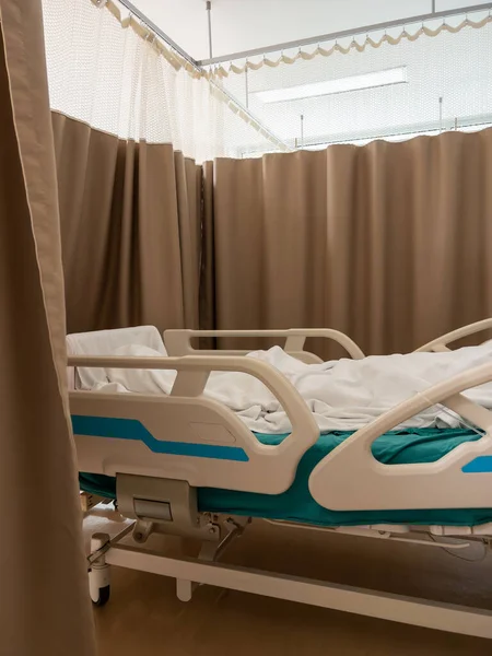 白い毛布の中に横たわっ患者と調整可能な病院のベッドは手術後に回復しています コピースペースとフロントビュー — ストック写真