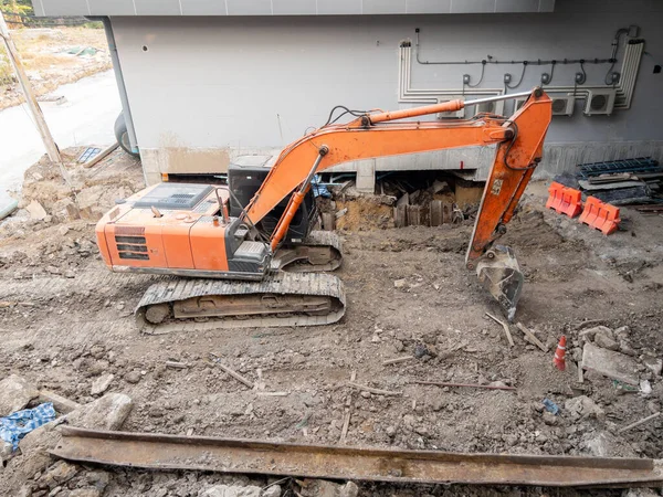 大型橙色挖掘机在城市建设单轨车站的现场 前视镜的复制空间 — 图库照片