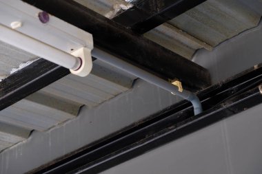 Şehir merkezindeki evin tavanından sarkan metal çerçevenin yakınındaki küçük elektrik kabloları, fotokopi alanının ön görüntüsü..