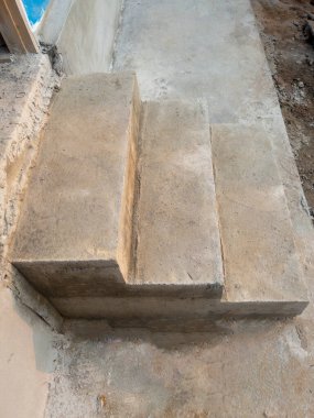 Şehir köyündeki inşaat evinin arkasındaki tamamlanmamış beton merdiven, fotokopi alanının olduğu ön manzara..