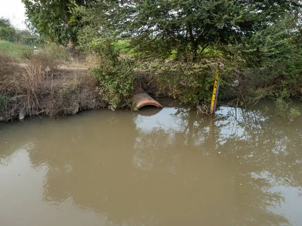 The irrigation canal with the water level gauge indicator to show the high water level for use in growing rice in the new season, front view with the copy space.