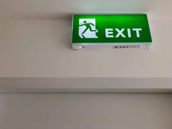 The green fire exit symbol on the ceiling shows escape routes outside the building when the fire, front view with the copy space.